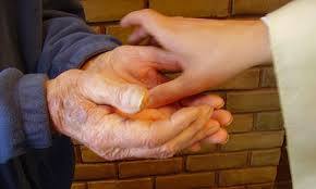Priest anointing the hands of a person